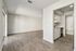 Spacious open-plan living area with modern wooden flooring, abundant natural light, and a sleek kitchen with white cabinetry and stainless steel appliances.