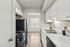Bright and modern kitchen with sleek black appliances, white cabinetry, and elegant marble countertops.