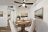 Chic dining area with a round wooden table, elegant upholstered chairs, and serene landscape artwork, perfect for warm gatherings.
