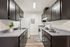 Sleek apartment kitchen with modern black cabinetry, pristine countertops, and stylish decor exuding contemporary charm.