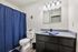 Elegant bathroom with sleek black vanity, spacious countertop, and stylish blue accents.