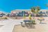 Inviting apartment complex with charming balconies, lush greenery, and outdoor seating area under a bright blue sky.