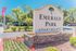 Elegant entrance sign for Emerald Park Apartments surrounded by lush greenery and vibrant landscaping.