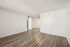 Bright and spacious living area with elegant wood flooring and modern ceiling fan, perfect for stylish living.