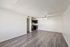 Bright, open-concept living area with modern flooring, adjoining kitchen, and ceiling fan for comfort and style.