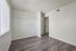 Bright and airy bedroom with sleek wood flooring, large window for natural light, and minimalist design.