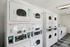 Modern apartment laundry room equipped with state-of-the-art stacked washers and dryers, offering convenience and efficiency.