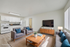 Virtually staged modern apartment showcasing an open-concept living and kitchen area with stylish furniture, cozy seating, and abundant natural light.