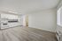 Bright and airy kitchen area with modern white cabinets, sleek countertops, and new appliances, featuring stylish wood flooring and natural light.
