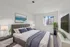 Elegantly staged bedroom with a cozy bed, modern decor, and abundant natural light.