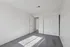 Bright, spacious bedroom featuring plush grey carpet and ample natural light, perfect for relaxation.