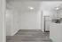 Modern open-concept space showcasing sleek flooring, bright kitchen, and ample natural light.