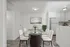 Elegant dining area with a glass table, modern chairs, and chic decor in a bright apartment setting.