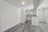 Bright and inviting open-concept kitchen with modern white cabinetry and sleek flooring, ideal for cozy living.