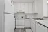 Bright and modern kitchen featuring sleek white cabinetry, spacious countertops, and stainless steel appliances.