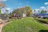 Vibrant apartment complex featuring lush green landscaping, palm trees, and ample parking under a clear blue sky.