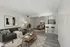 Elegant open-plan living area with modern decor, featuring a cozy lounge, stylish dining space, and contemporary kitchen with sleek stools.