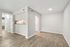 Bright and modern living space with sleek hardwood flooring, archway entrance, and a cozy kitchen nook.