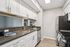 Modern kitchen with sleek stainless steel appliances and chic white cabinetry, complemented by elegant countertops and stylish flooring.