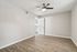 Bright, spacious room featuring sleek wooden flooring and a modern ceiling fan, ideal for stylish living.