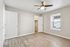 Bright and airy bedroom featuring sleek wood flooring, a modern ceiling fan, and a large window offering natural light.