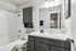 Elegant bathroom with modern fixtures, stylish vanity, and a spacious mirror reflecting natural light.