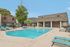 Inviting apartment complex with a refreshing swimming pool surrounded by modern lounge chairs and lush greenery.