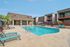 Inviting apartment complex featuring a well-maintained swimming pool area with stylish lounge chairs and vibrant greenery, perfect for relaxation.