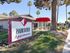 Inviting entrance to Parkwood Apartments, showcasing vibrant landscaping and a chic red awning.