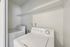 Modern laundry area with energy-efficient washer and dryer set, white interior walls, and convenient shelving.
