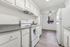 Bright kitchen with modern white cabinets, sleek countertops, and stylish wood flooring, offering a fresh and airy space ideal for culinary creativity.