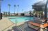 Inviting outdoor pool area with palm trees and modern sun loungers, perfect for relaxation and enjoyment.
