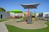 Vibrant playground area with colorful slides and shade structures, set amidst a modern apartment complex.