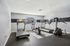 Modern fitness room with state-of-the-art treadmills and exercise equipment, complemented by ample natural light through a large window.