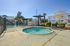 Inviting outdoor area featuring a sparkling pool and relaxing spa, surrounded by palm trees and lush greenery, perfect for unwinding in the sun.