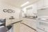 Modern kitchen with sleek white cabinetry, stainless steel sink, and cozy breakfast bar for casual dining.