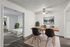 Elegantly staged apartment showcasing a stylish dining area with modern chairs and a wooden table, adjacent to a cozy bedroom with plush carpeting and fresh decor.