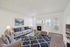 Elegant living room with modern gray sofas, a cozy fireplace, and vibrant blue decor, featuring natural light and contemporary furnishings.