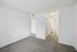Bright and inviting bedroom with plush carpet, contemporary white walls, and convenient ensuite bathroom access.