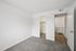 Bright and inviting bedroom with plush carpet, featuring a spacious walk-in closet and convenient in-unit laundry space.