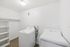 Chic and modern laundry room featuring sleek white washer and dryer units, enhanced by elegant shelving and warm wood flooring.