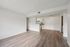 Spacious and modern open-plan living area with elegant wooden flooring and a sleek, minimalist kitchen design.