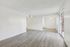 Spacious modern living area with sleek wood flooring, abundant natural light through large sliding glass doors, and a ceiling fan for enhanced comfort.