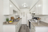 Bright and inviting kitchen with modern white cabinets, sleek countertops, and elegant appliances, perfect for culinary enthusiasts.