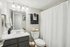 Modern bathroom with elegant fixtures, large mirror, and neutral decor featuring plush towels and chic accessories.
