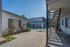 Inviting courtyard with vibrant greenery and gated pool access, nestled between two charming apartment buildings.