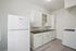 Bright and inviting kitchen with modern white cabinetry, sleek countertop, and efficient appliances, perfect for culinary creativity.