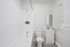 Bright, modern bathroom featuring a sleek white bathtub, pristine vanity, and elegant fixtures.