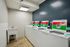 Modern laundry room featuring efficient top-loading washers, a utility sink, and sleek tile flooring.