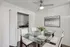 Chic dining area with elegant glass table set for four, modern art on the wall, and a convenient in-unit laundry nook.